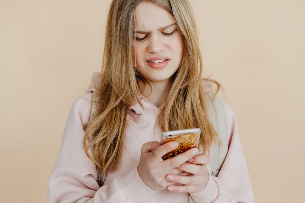Femme qui consulte son téléphone parce qu'il ne répond plus à ses messages