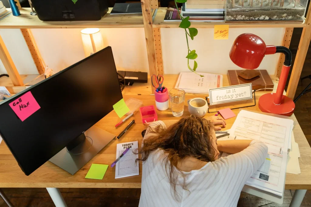 Femme notant ses symptômes de syndrome prémenstruel dans un agenda de suivi du cycle