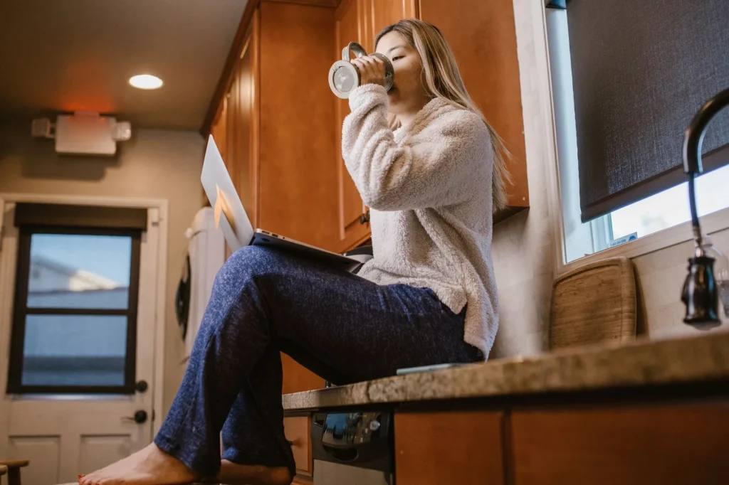 Femme buvant un grand verre d'eau, le geste le mieux démontré contre la cystite à répétition