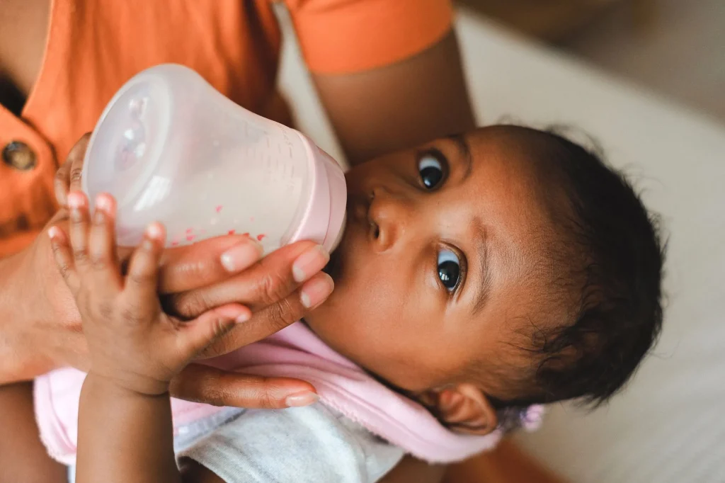Mère tenant son bébé à la verticale contre son épaule pour limiter le reflux du nourrisson