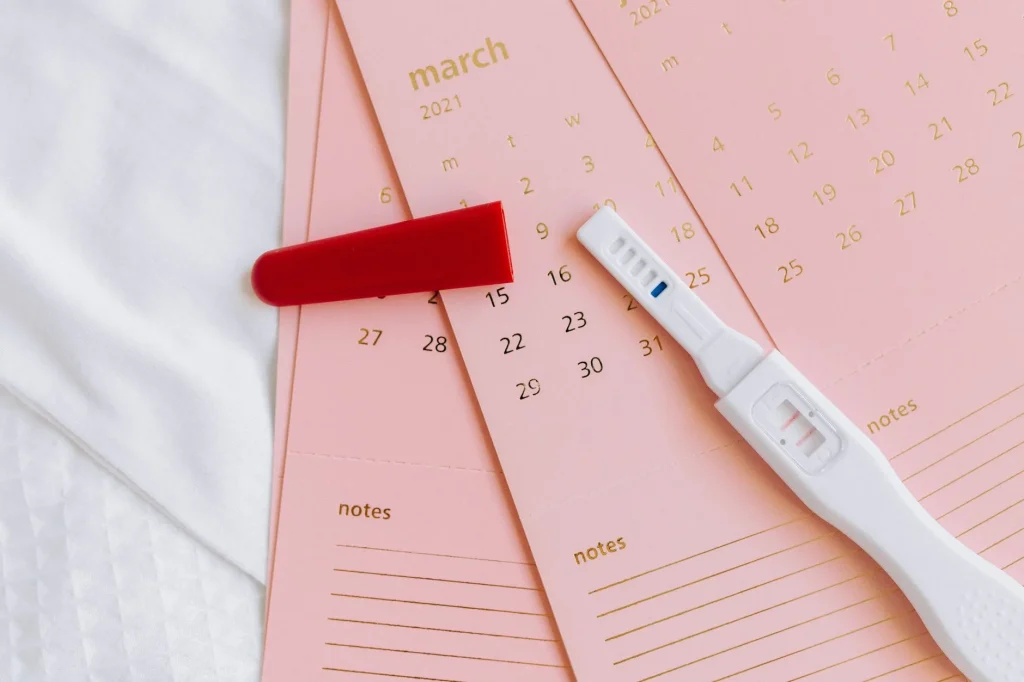 Future maman calculant sa date d'accouchement en semaines sur un calendrier de grossesse