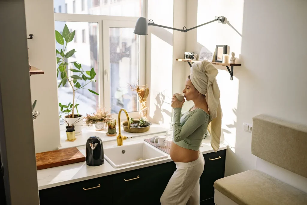Femme enceinte tenant une tasse de thé vert, entre caféine et absorption du fer